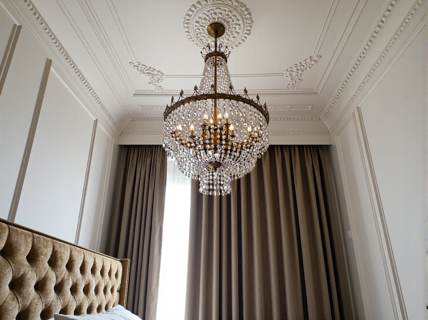 Szklane i złote dekoracje na komodzie w stylu glamour.