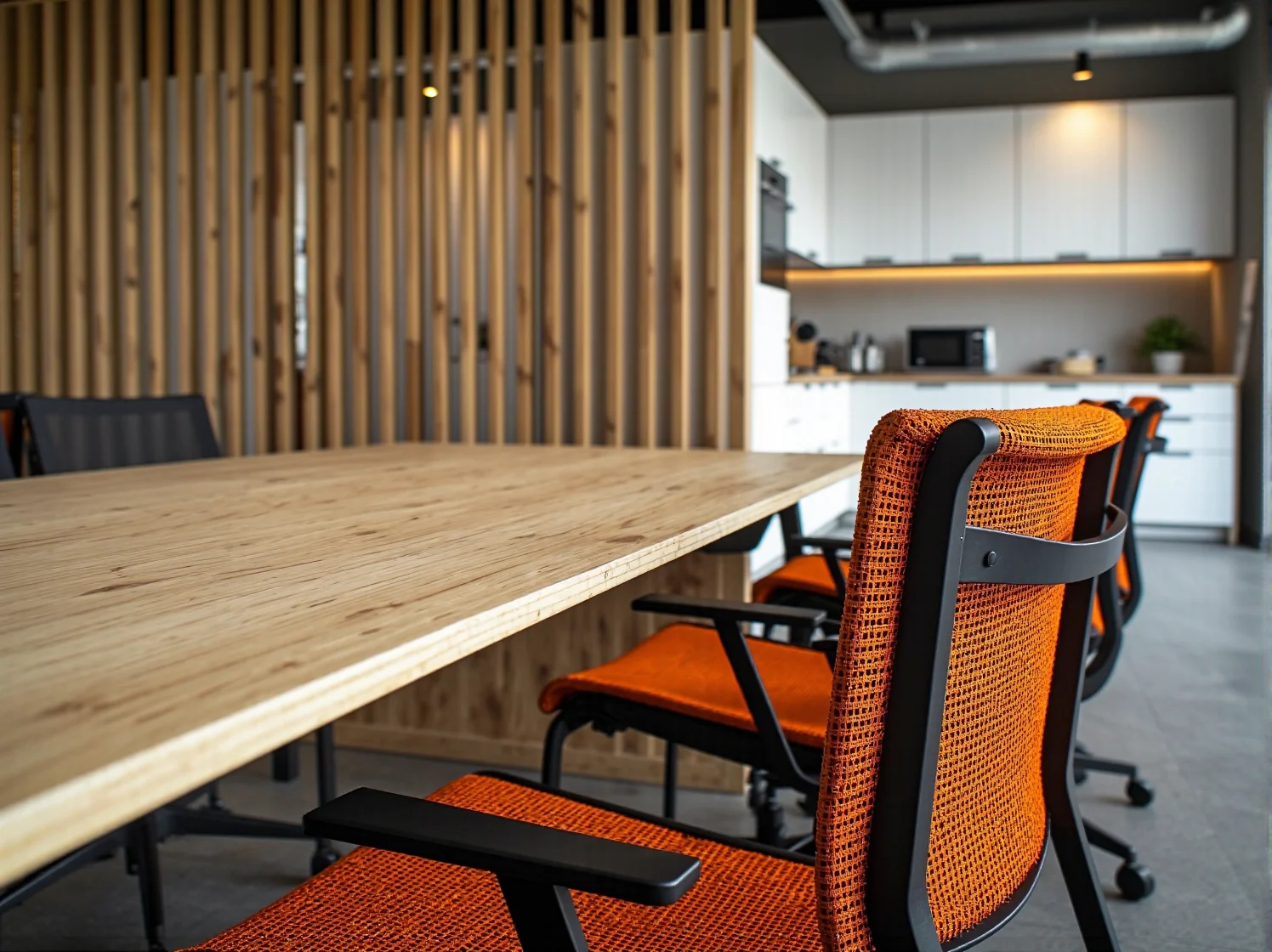 Aneks kuchenny w coworkingu z wysokim stołem i hokerami.